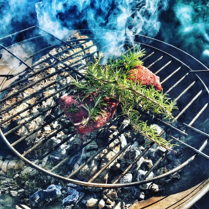 rosemary on meat on a grill
