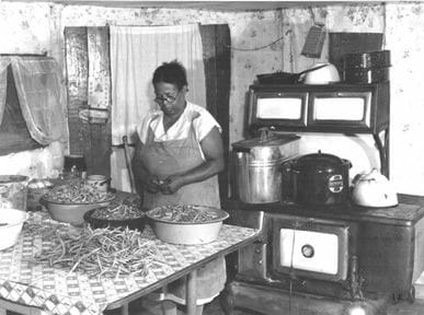black and white image of a woman canning food