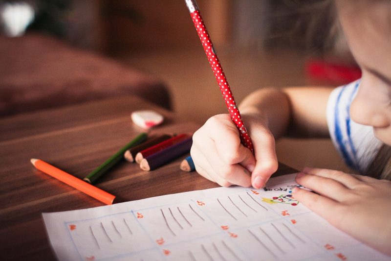 child writing labels