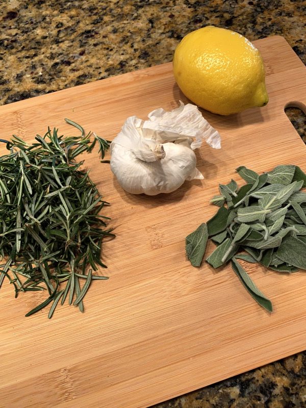 herbs on cutitng board, rosemary, garlic, lemon, sage