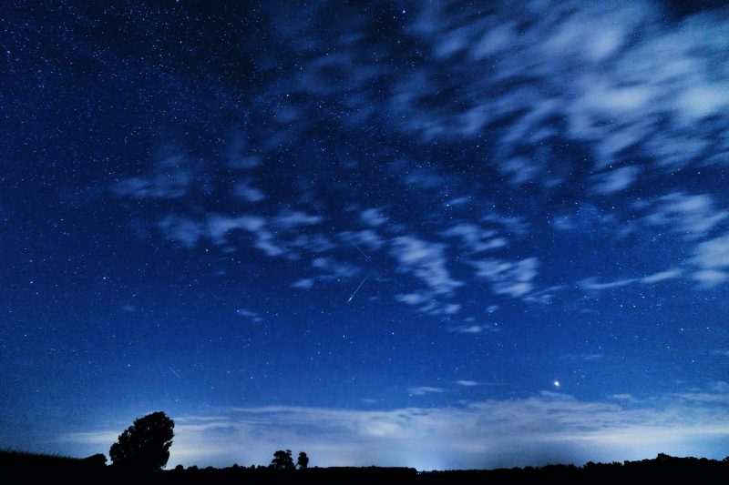 meteor shower in blue night sky