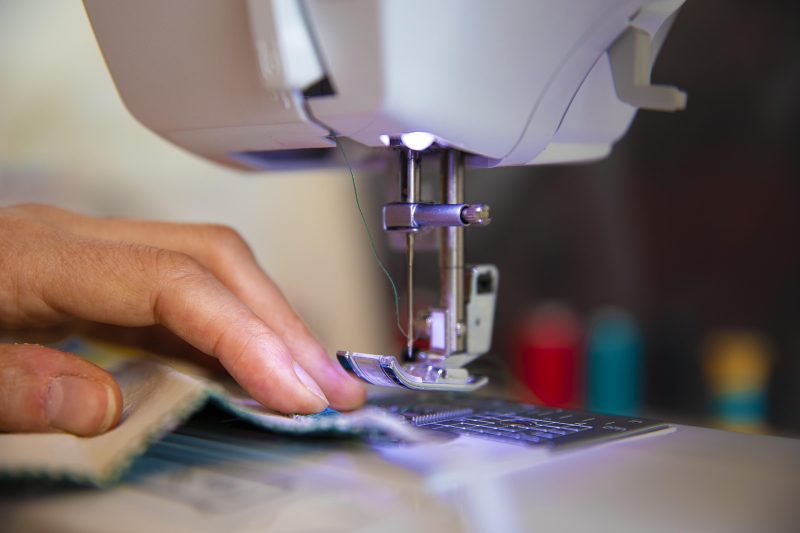 mand guiding cloth under the needle of a sewing machine