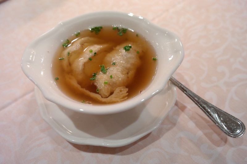 herbs sitting in a bowl of soup at a chinese restaurant